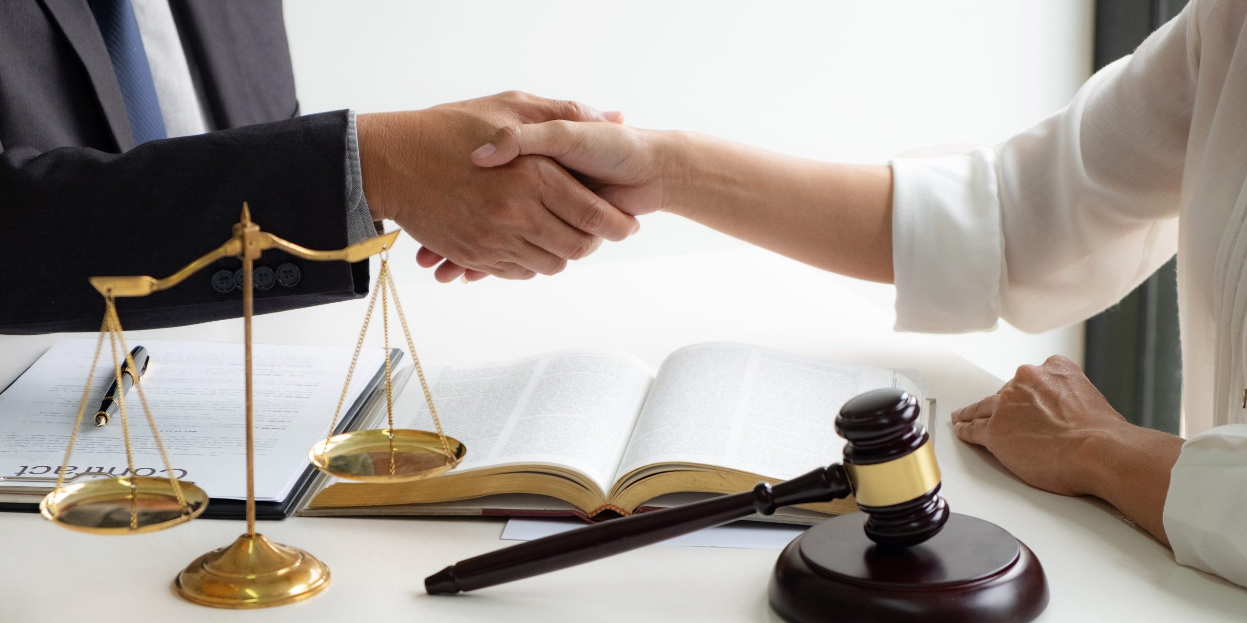 lawyer consultant with client shaking hands together with contract agreement.